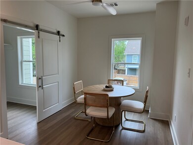Dining room with a ceiling fan, a barn door, dark