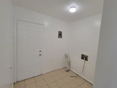 Clothes washing area with light tile patterned flo