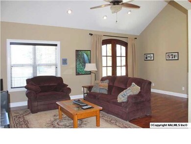 Living area has vaulted ceiling, wood floors, recessed lighting.