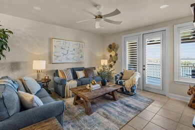 Living area with light tile patterned flooring, a wealth of natural light, baseboards, and ceiling fan