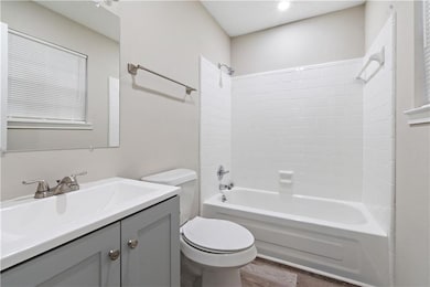 Full bathroom with shower / bathing tub combination, toilet, wood-type flooring, and large vanity
