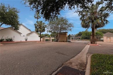 View of street with a gated entry, curbs, and a gate