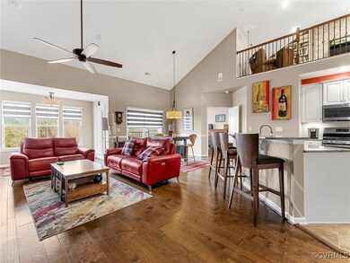 Living area featuring visible vents, high vaulted