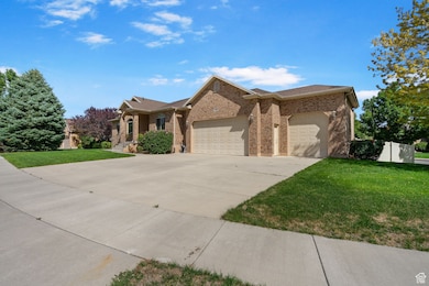 Single story home featuring an attached garage, a front yard, concrete driveway, brick siding