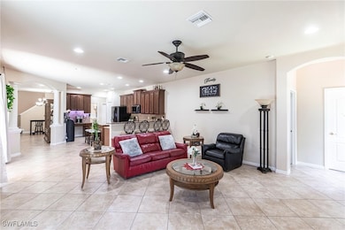 Living room featuring arched walkways, a ceiling f