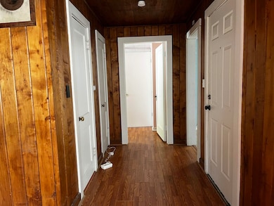 Hall featuring dark wood finished floors, wooden w