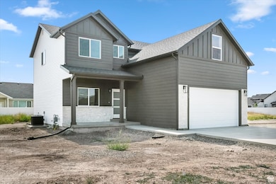 View of front facade with board and batten siding, a porch, and brick siding