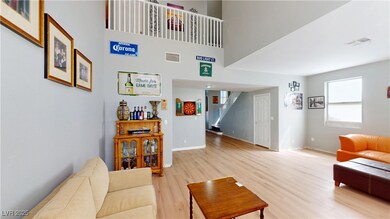 Living area with stairway, baseboards, visible ven