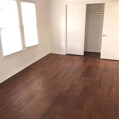 Unfurnished bedroom featuring dark wood-type floo