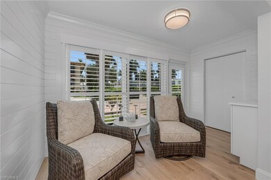 Living area featuring a healthy amount of sunlight, light wood-type flooring, and crown molding