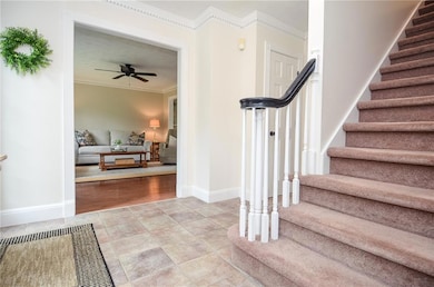 Stairway featuring crown molding, baseboards, and 