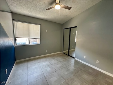 Unfurnished bedroom featuring a textured ceiling, a closet, and ceiling fan