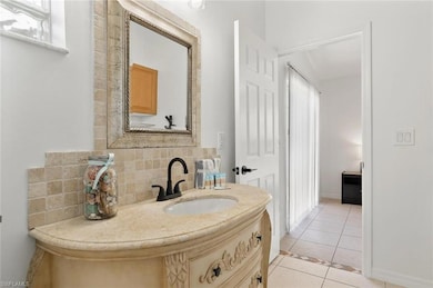 Bathroom with vanity, baseboards, backsplash, and 