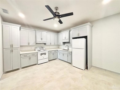 Kitchen featuring white appliances, backsplash, light countertops, a ceiling fan, and ventilation hood