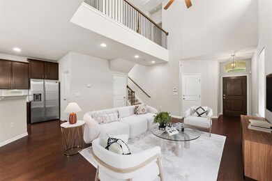 Living room with stairs, dark wood-style floors, 