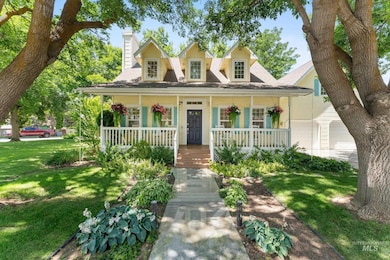 New england style home with a chimney, covered porch, a front lawn, and a shingled roof