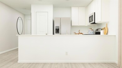Kitchen featuring fridge with ice dispenser, light