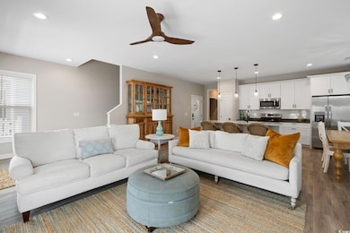 Living area with wood finished floors, ceiling fan
