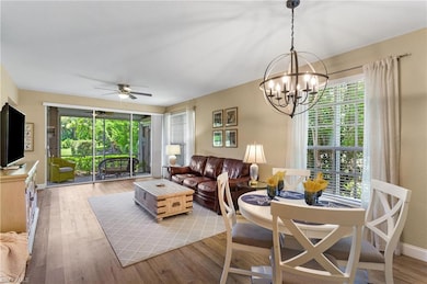 Living room featuring wood finished floors, a ceiling fan, and a chandelier