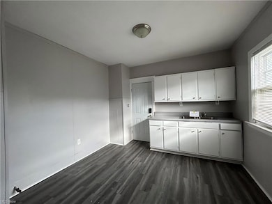 Kitchen with dark hardwood floors and white cabinetry
