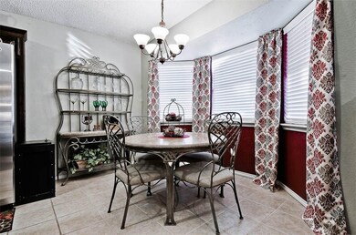 Eat-in kitchen with bay windows and tile flooring.