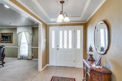 Entrance foyer with a tray ceiling, light carpet, 