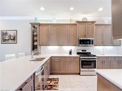 Kitchen featuring ornamental molding, sink, appliances with stainless steel finishes, and a breakfast bar