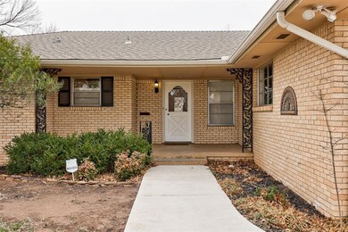 Entrance to property with a shingled roof, brick s