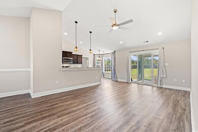 Unfurnished living room with ceiling fan, dark har