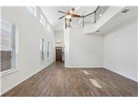 Unfurnished living room featuring ceiling fan, wo