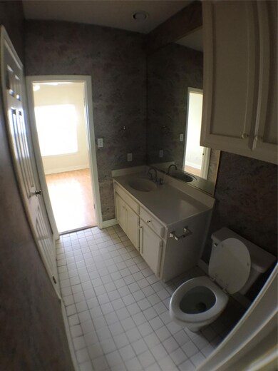 Bathroom featuring toilet, wallpapered walls, van