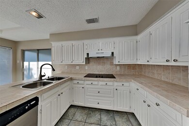 Kitchen with sink, stainless steel dishwasher, whi