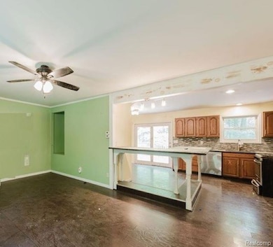 Unfurnished living room featuring healthy amount of natural light, crown molding, dark wood-style floors, and ceiling fan