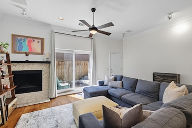 Living area featuring crown molding, a fireplace, wood finished floors, ceiling fan, and recessed lighting