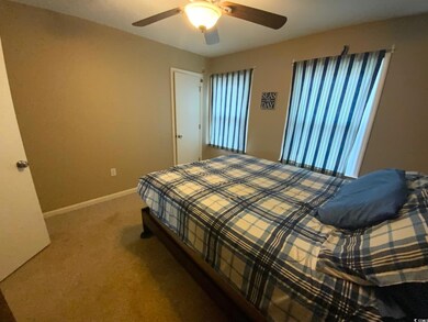 Carpeted bedroom featuring ceiling fan
