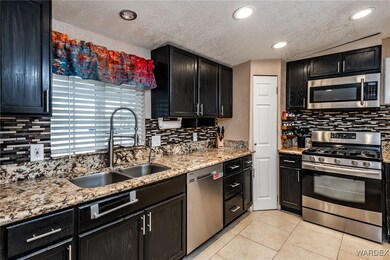Kitchen featuring dark cabinetry, light tile patte