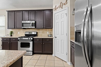 The kitchen is just across from the dining room and has tile flooring, gas range, undermount microwave, corner pantry and tons of cabinet/counterspace.