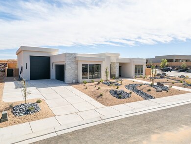 Modern home with stone siding, stucco siding, driveway, and an attached garage