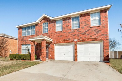 View of front facade featuring a garage, brick sid