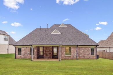 Rear view of house with a patio area, roof with shingles, and brick siding