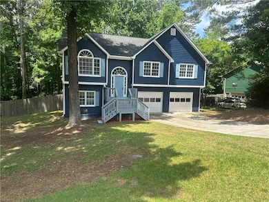 Bi-level home featuring an attached garage and dri