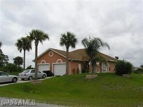 Ranch-style home featuring a garage and a front ya