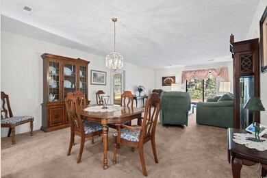 Carpeted dining space with a chandelier
