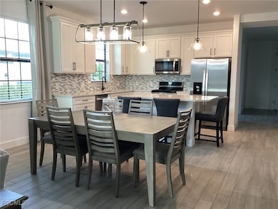 Dining room with light wood-type flooring and recessed lighting