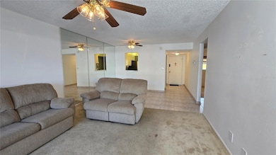 Another view of the living room and dining room as well as the front door entrance and kitchen.