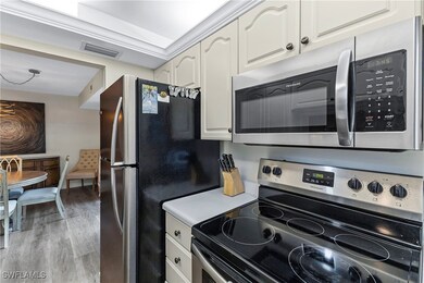 Kitchen featuring appliances with stainless steel finishes, light wood-type flooring, light countertops, and a chandelier