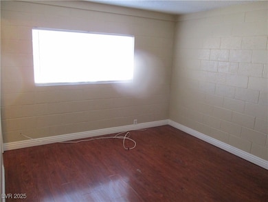 Empty room featuring wood finished floors, baseboa