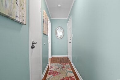 Hall with crown molding and hardwood / wood-style 