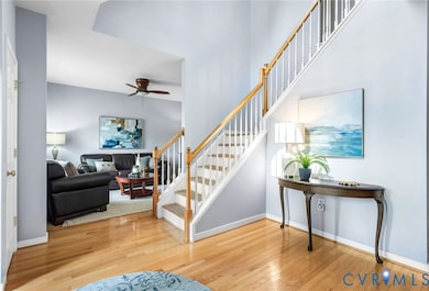 Staircase featuring hardwood / wood-style flooring and ceiling fan