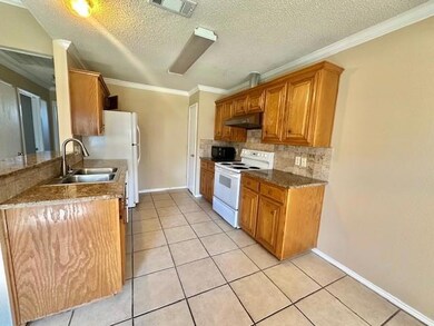 Kitchen with crown molding, tasteful backsplash, l